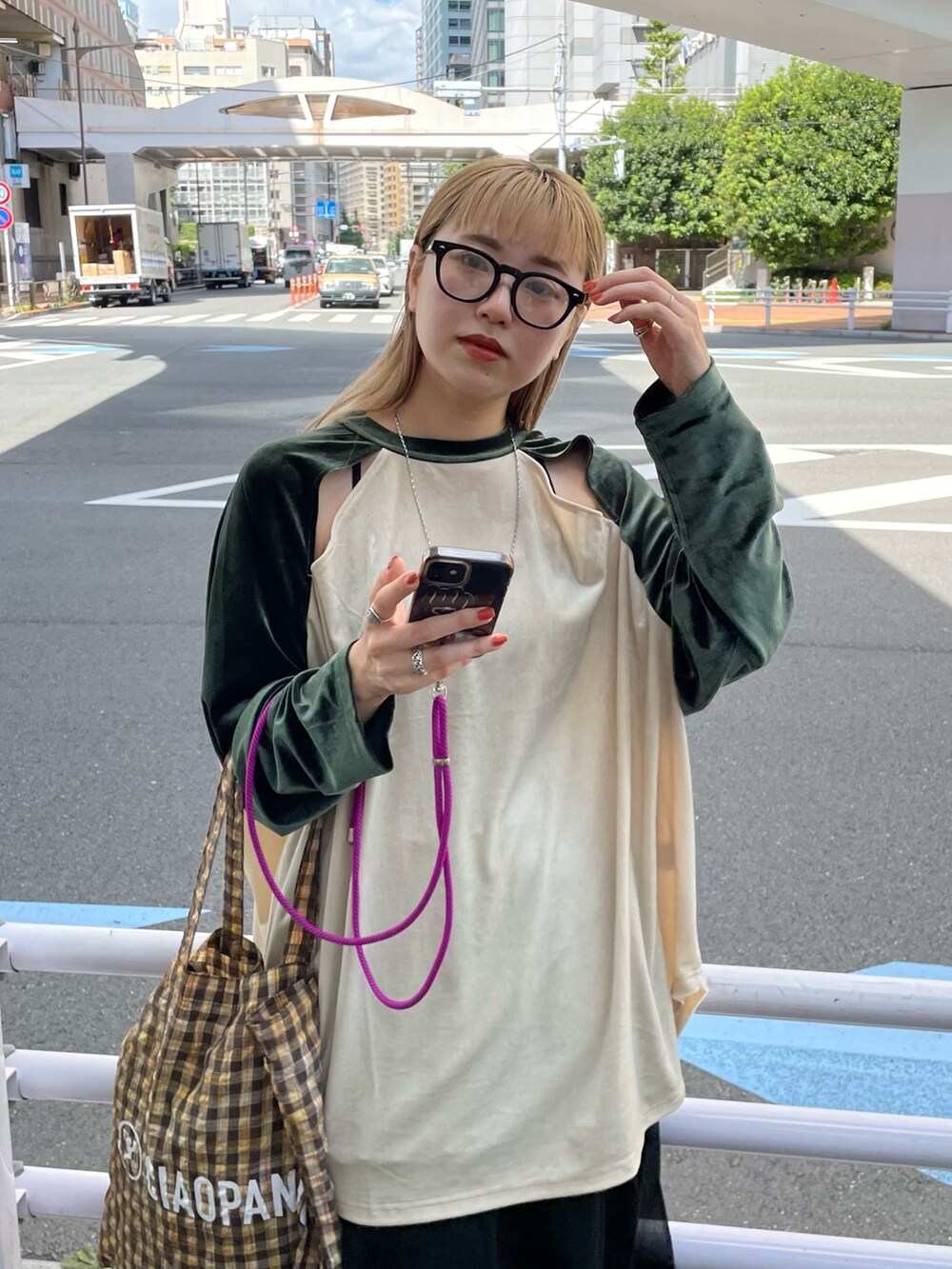 グリーン系のTシャツ/カットソー、イエロー系のトートバッグ、ブラック系のスカートを着用したレディースの秋コーディネートの3枚目の写真