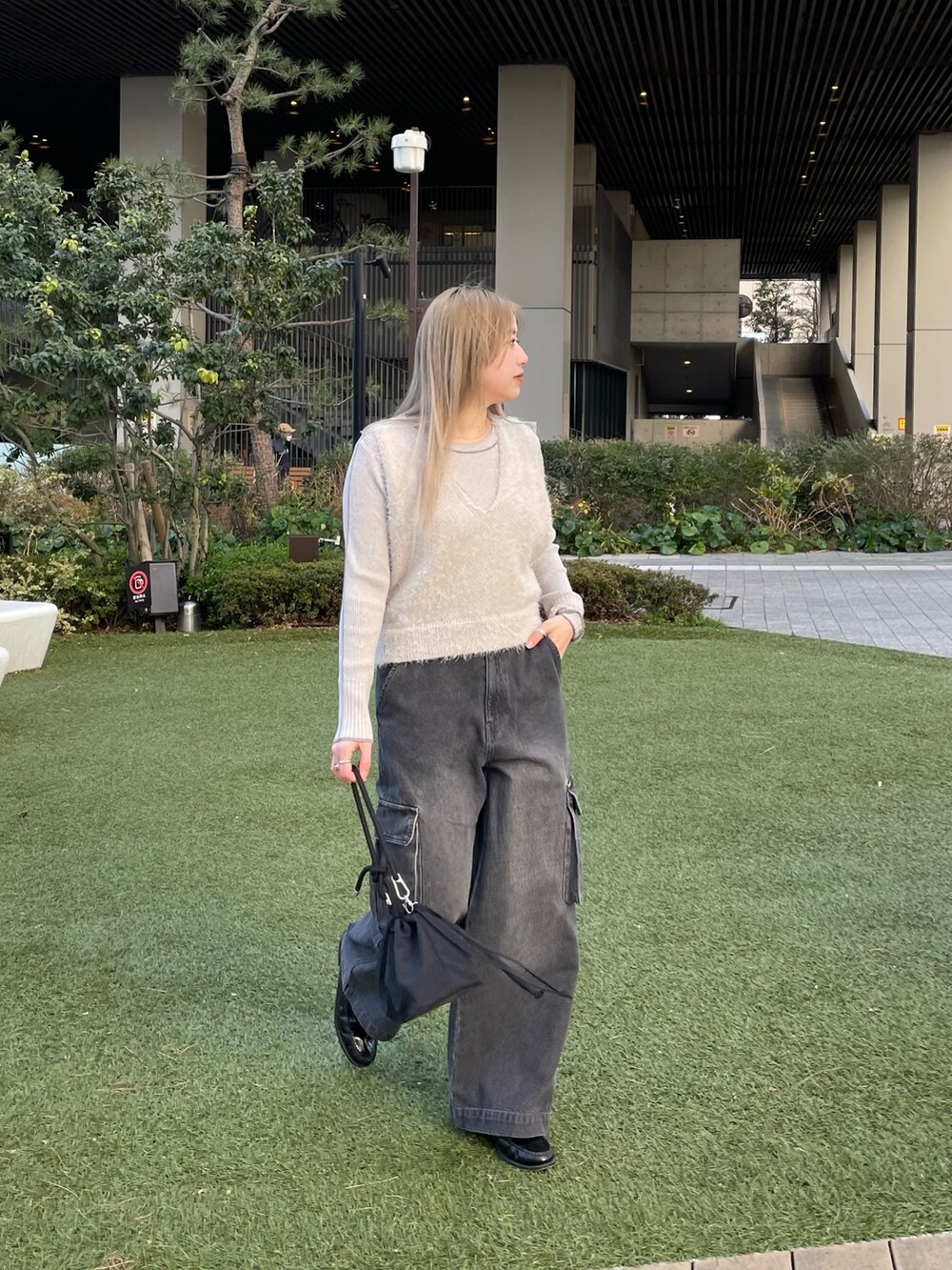 グレー系のベスト、グレー系のニット/セーター、ブラック系のバッグを着用したレディースの冬コーディネートの2枚目の写真