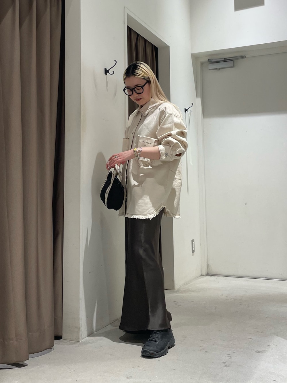 ホワイト系のデニムジャケット、グレー系のスカートを着用したレディースの春コーディネートの7枚目の写真