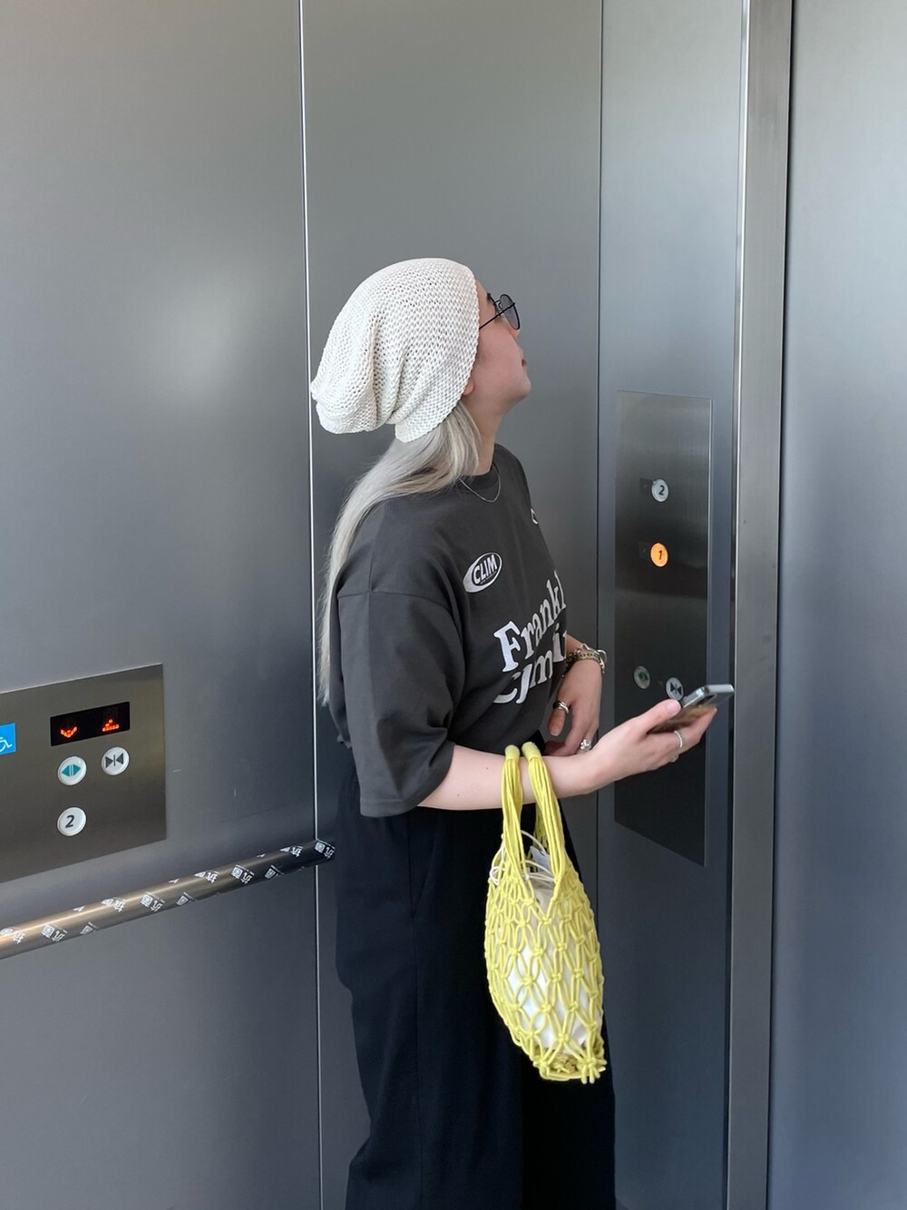 グレー系のTシャツ/カットソー、イエロー系のバッグ、ホワイト系のニットキャップ/ビーニーを着用したレディースの夏コーディネートの6枚目の写真