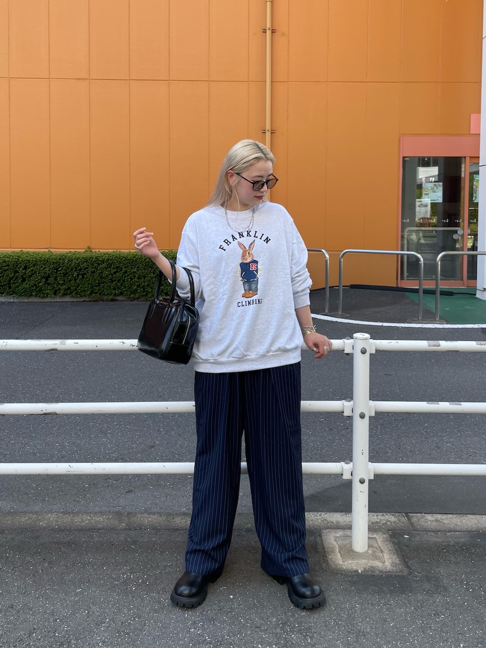 ブルー系のスラックス、ブラック系のボストンバッグ、グレー系のスウェットを着用したレディースの秋コーディネートの7枚目の写真