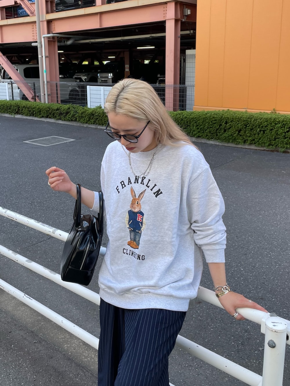 ブルー系のスラックス、ブラック系のボストンバッグ、グレー系のスウェットを着用したレディースの秋コーディネートの2枚目の写真