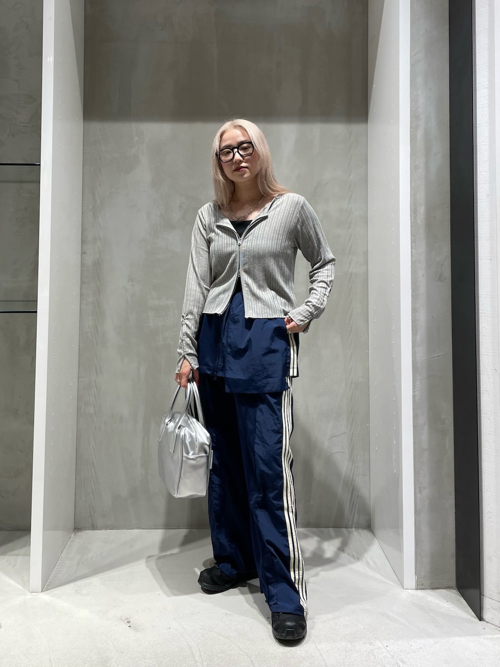 グレー系のカーディガン/ボレロ、ブルー系のスカート、ブルー系のスウェットパンツを着用したレディースの秋コーディネートの6枚目の写真