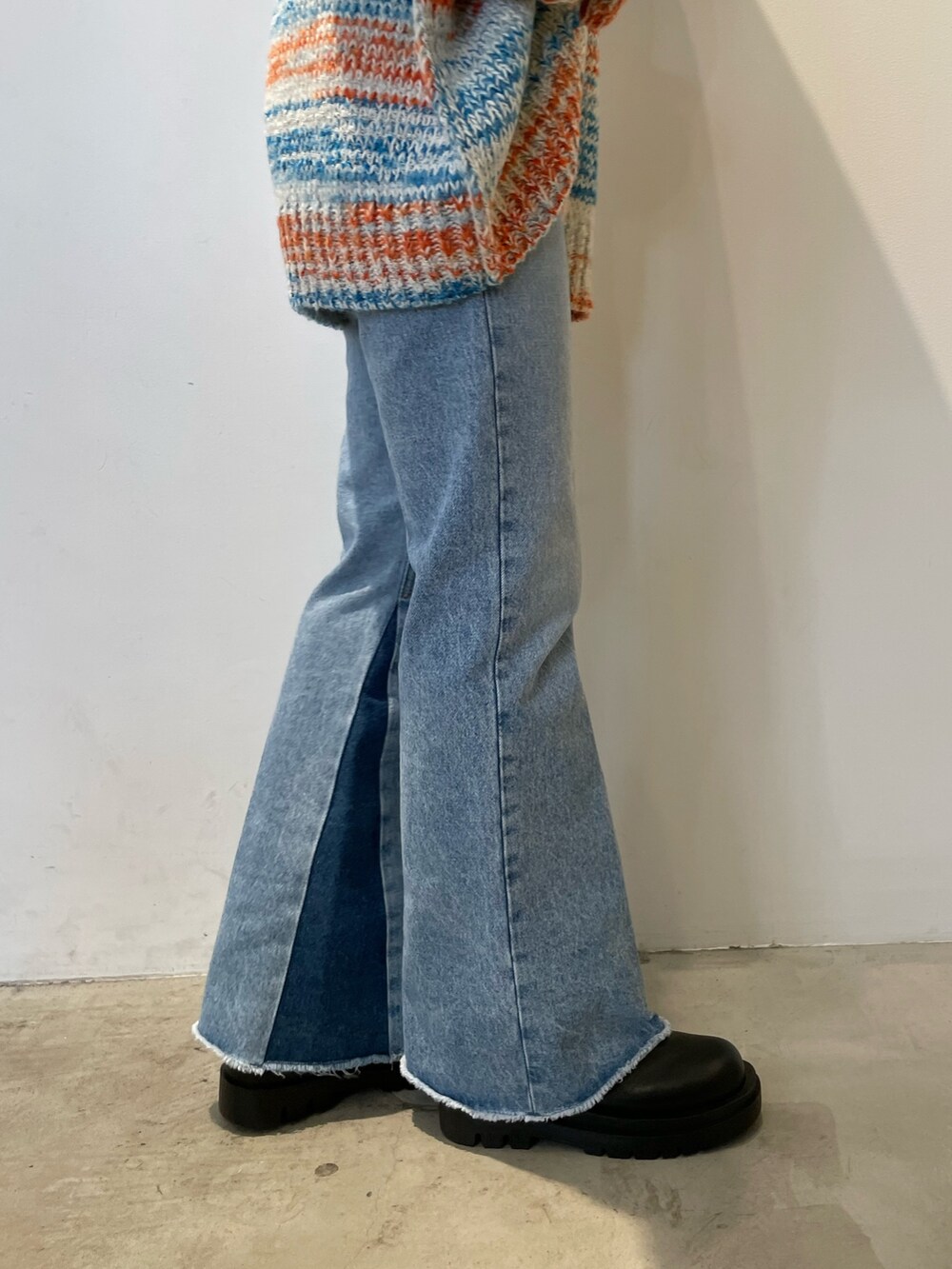 ホワイト系のカーディガン/ボレロ、ブラック系のバッグ、ブルー系のデニムパンツを着用したレディースの秋コーディネートの9枚目の写真