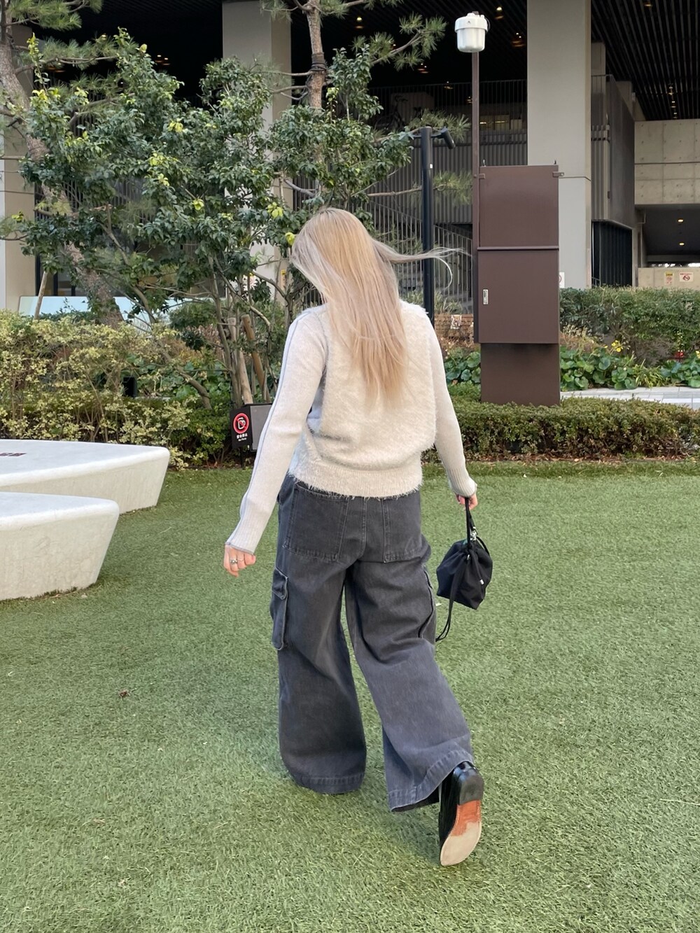 グレー系のベスト、グレー系のニット/セーター、ブラック系のバッグを着用したレディースの冬コーディネートの7枚目の写真