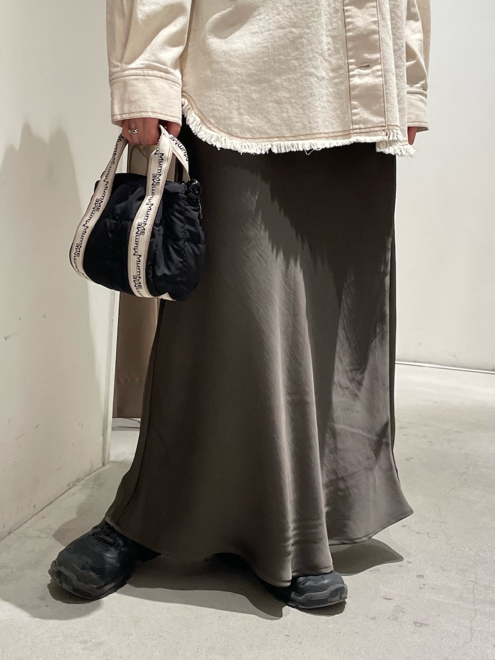 ホワイト系のデニムジャケット、グレー系のスカートを着用したレディースの春コーディネートの5枚目の写真