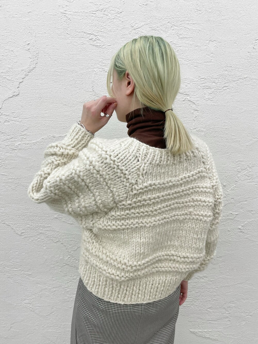 ホワイト系のカーディガン/ボレロ、グリーン系のスカートを着用したレディースの秋コーディネートの4枚目の写真