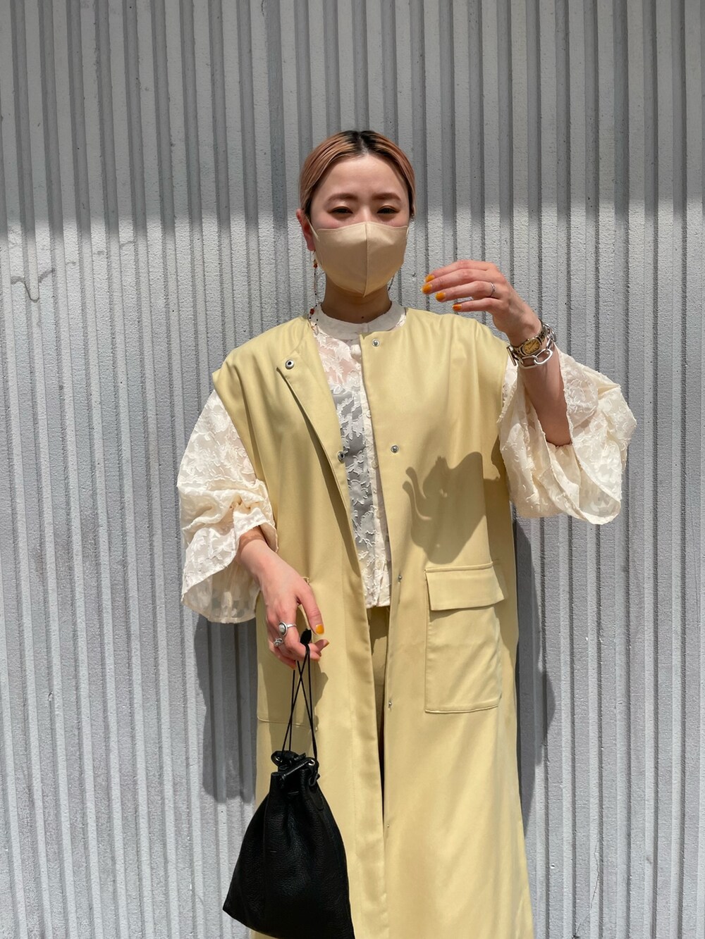 イエロー系のベスト、ホワイト系のシャツ/ブラウス、イエロー系のスラックスを着用したレディースの春コーディネートの5枚目の写真