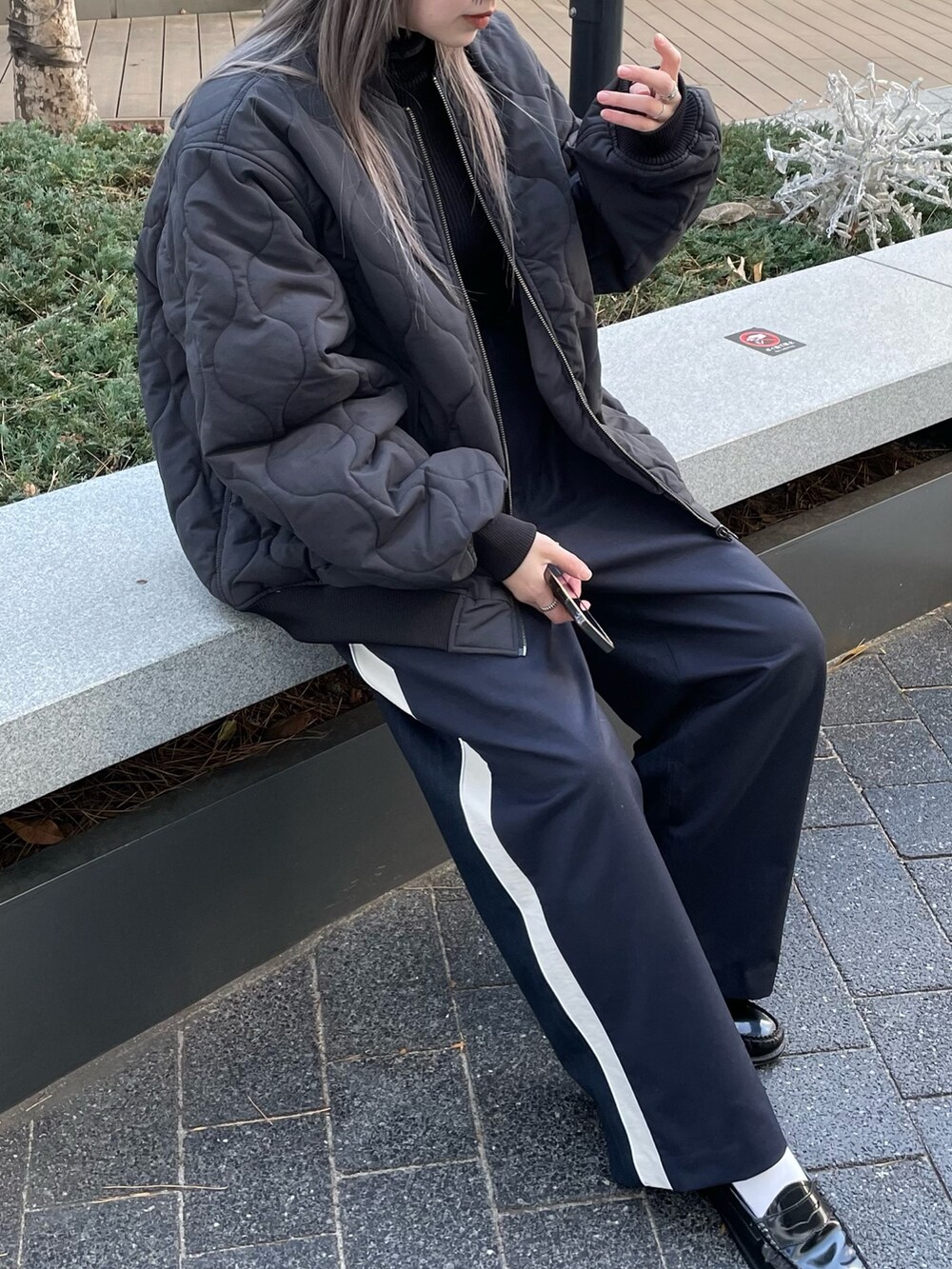 ブラック系のジャケット/アウター、ブラック系のニット/セーター、ブルー系のスラックスを着用したレディースの冬コーディネートの6枚目の写真