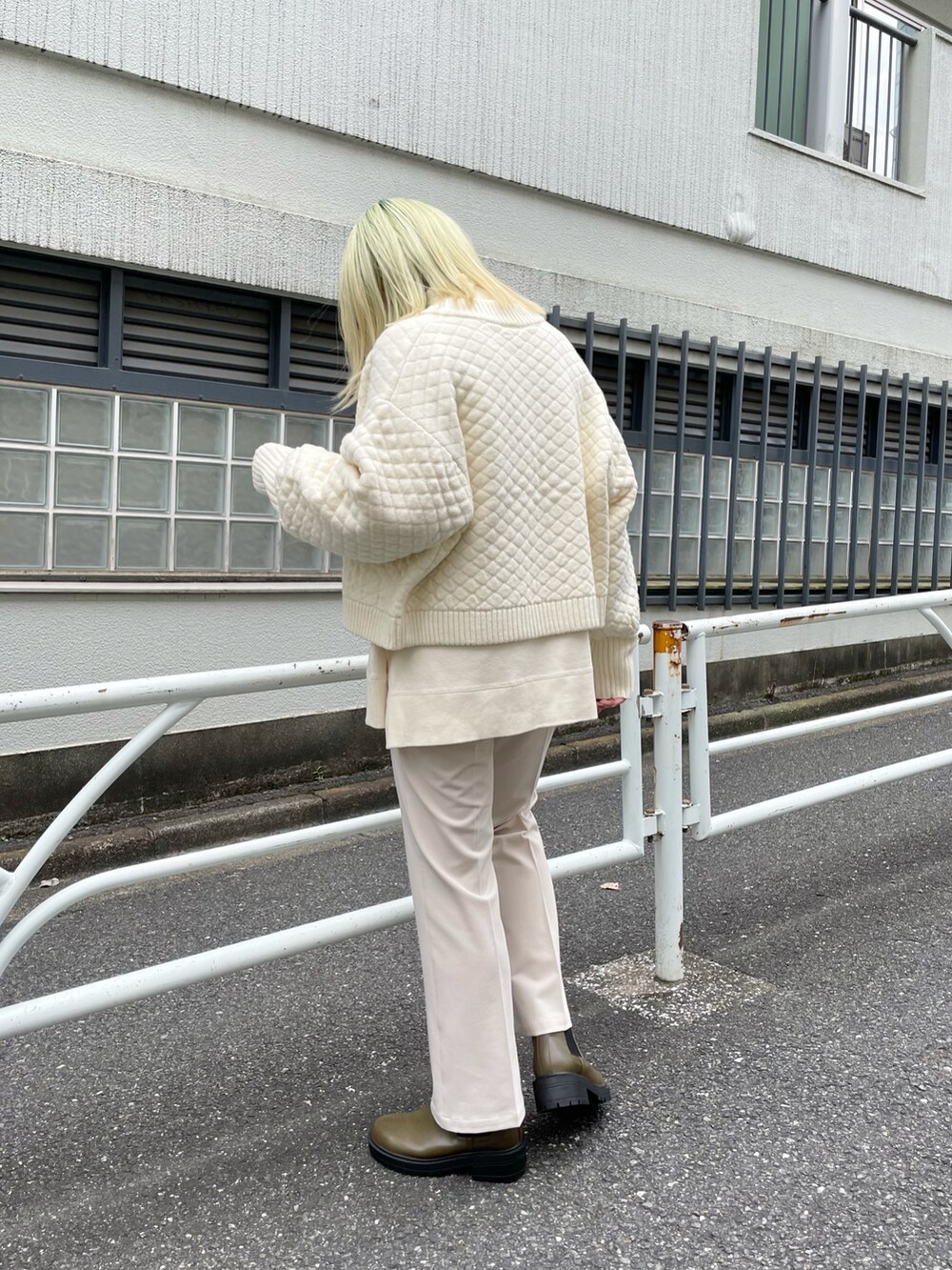 ホワイト系のニット/セーター、ホワイト系のカーディガン/ボレロ、グリーン系のブーツを着用したレディースの秋コーディネートの2枚目の写真