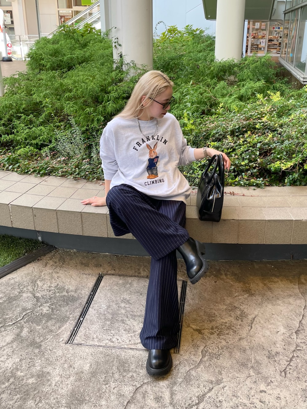 ブルー系のスラックス、ブラック系のボストンバッグ、グレー系のスウェットを着用したレディースの秋コーディネートの3枚目の写真