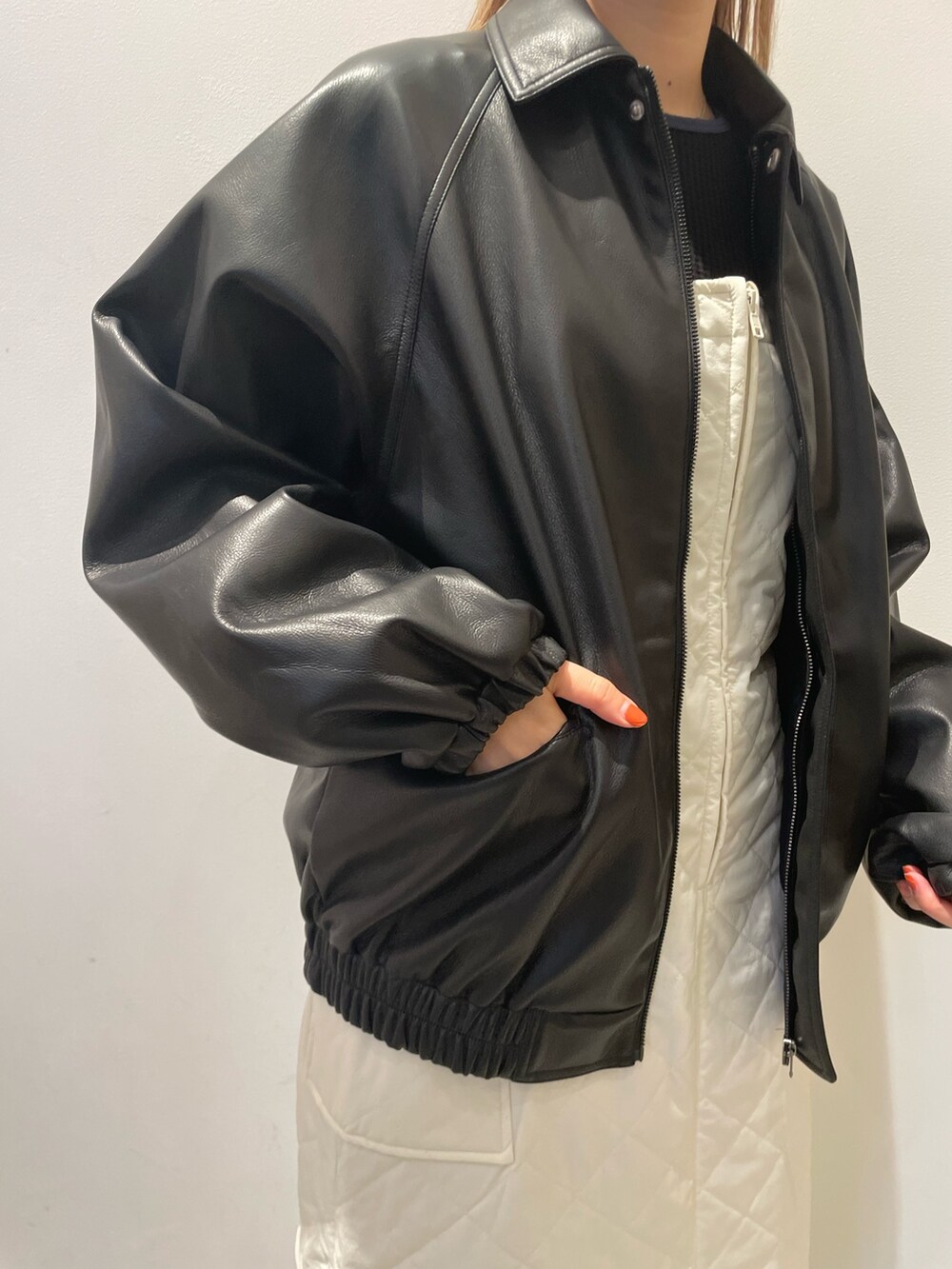 ブラック系のブルゾン、ブラック系のTシャツ/カットソー、ホワイト系のジャンパースカートを着用したレディースの秋コーディネートの2枚目の写真