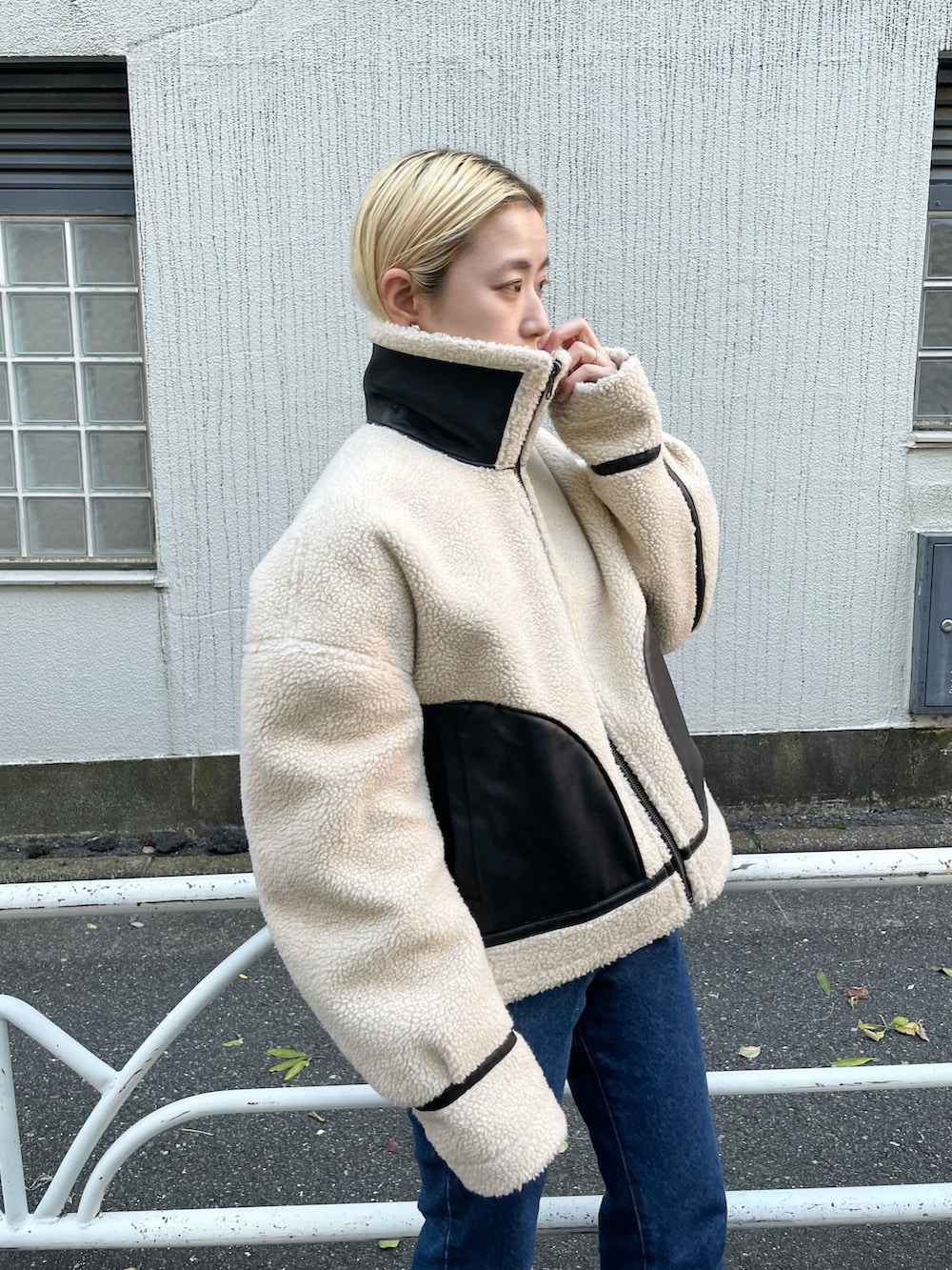 ホワイト系のTシャツ/カットソー、ブラック系のブルゾン、ブルー系のデニムパンツを着用したレディースの秋コーディネートの2枚目の写真