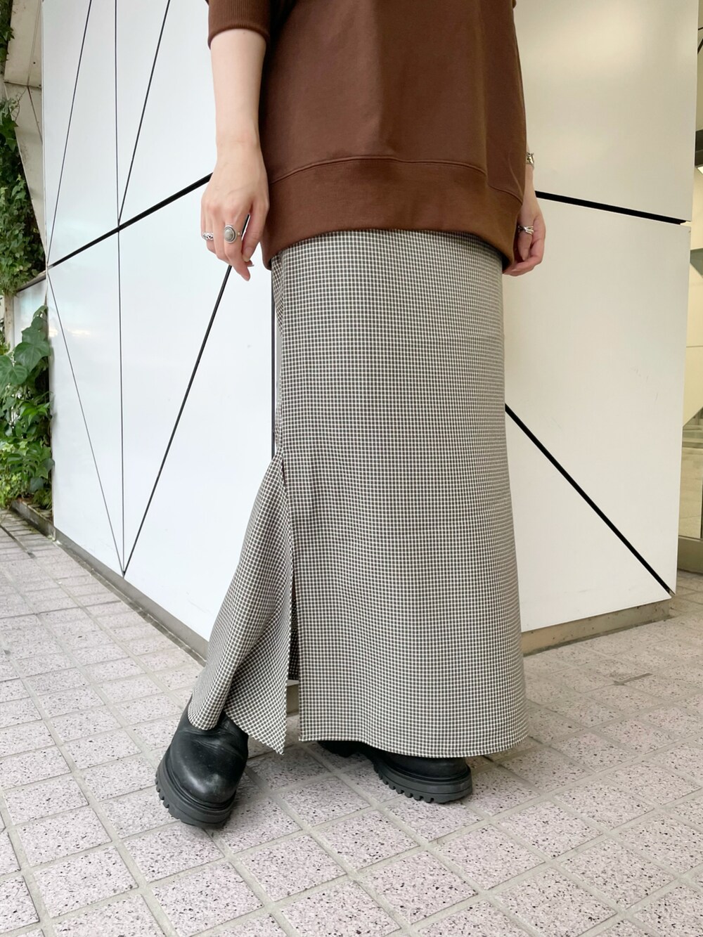 ブラウン系のスウェット、ブラック系のスカートを着用したレディースの秋コーディネートの4枚目の写真