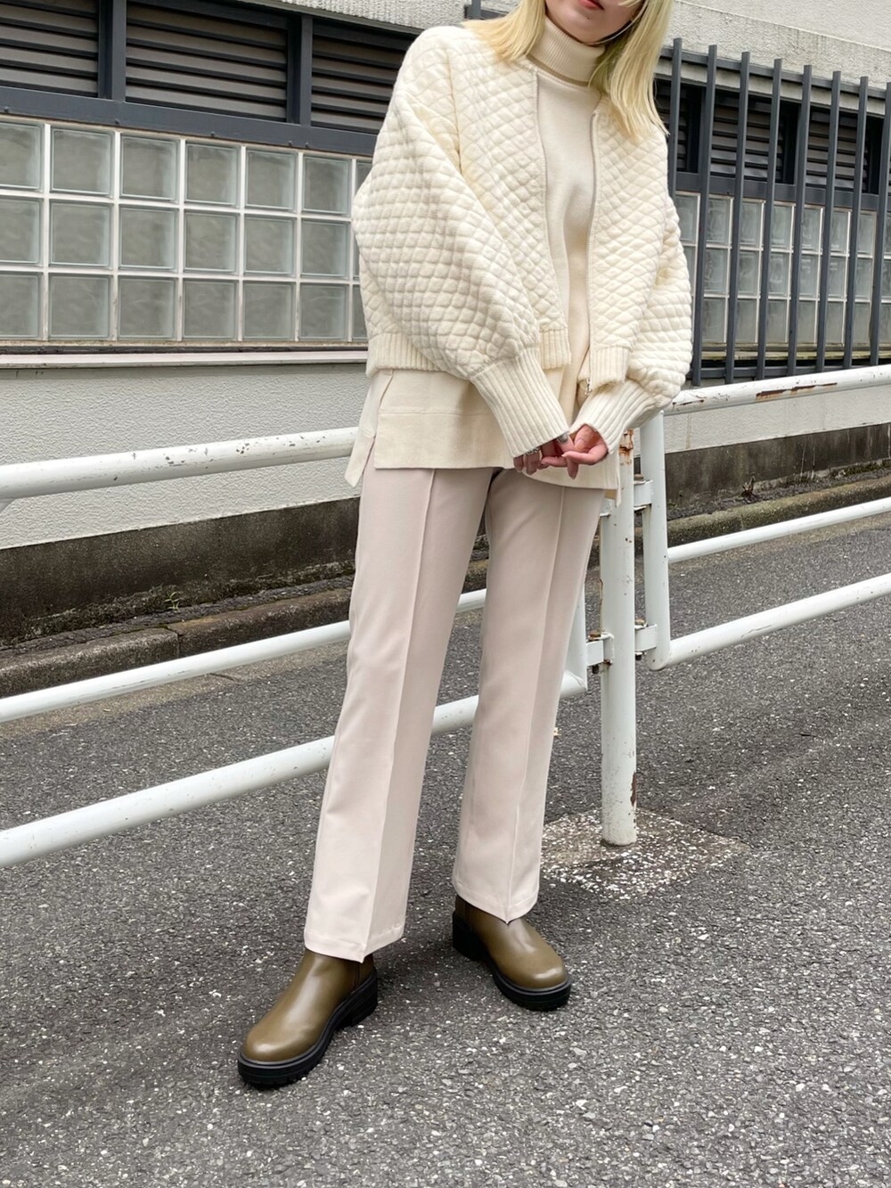 ホワイト系のニット/セーター、ホワイト系のカーディガン/ボレロ、グリーン系のブーツを着用したレディースの秋コーディネートの3枚目の写真