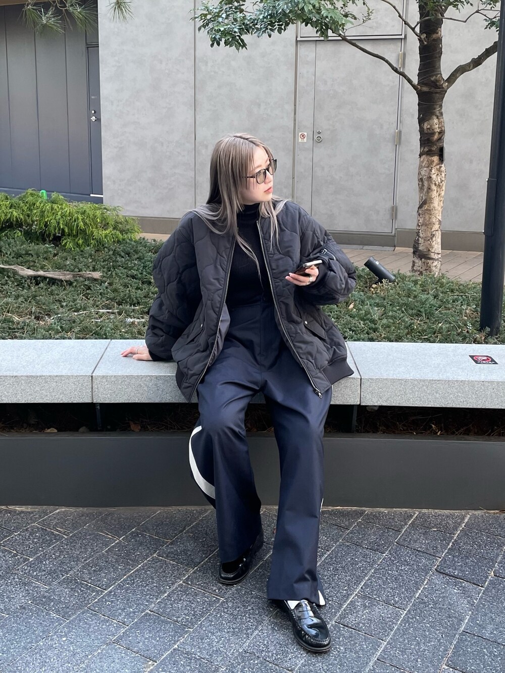 ブラック系のジャケット/アウター、ブラック系のニット/セーター、ブルー系のスラックスを着用したレディースの冬コーディネートの4枚目の写真