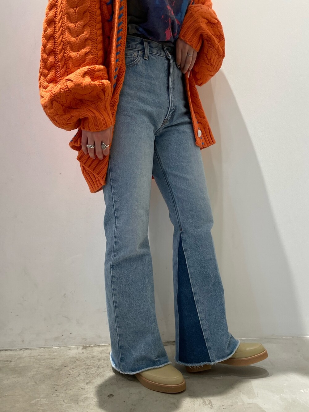 オレンジ系のカーディガン/ボレロ、ブルー系のデニムパンツ、ベージュ系のトートバッグを着用したレディースの秋コーディネートの5枚目の写真