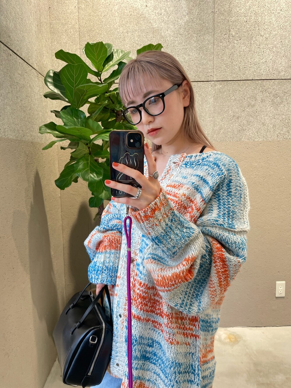 ホワイト系のカーディガン/ボレロ、ブラック系のバッグ、ブルー系のデニムパンツを着用したレディースの秋コーディネートの3枚目の写真