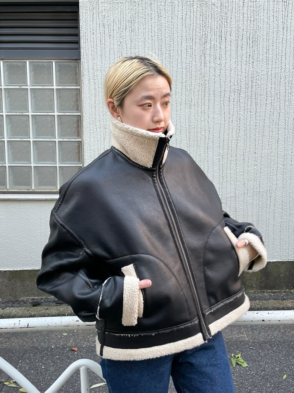 ホワイト系のTシャツ/カットソー、ブラック系のブルゾン、ブルー系のデニムパンツを着用したレディースの秋コーディネートの5枚目の写真