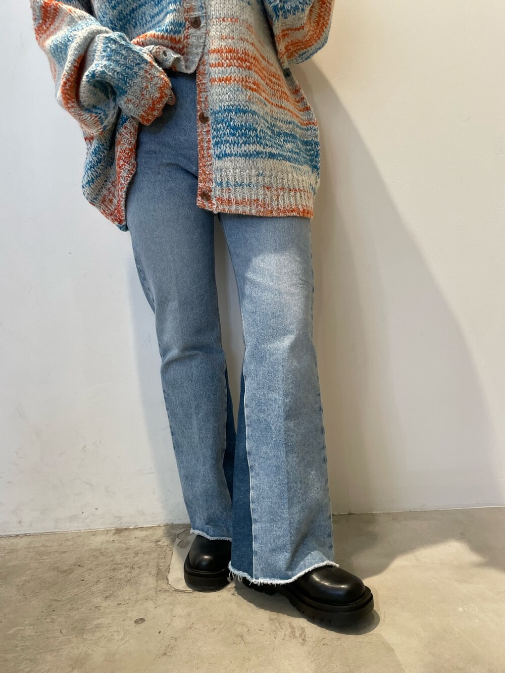 ホワイト系のカーディガン/ボレロ、ブラック系のバッグ、ブルー系のデニムパンツを着用したレディースの秋コーディネートの8枚目の写真