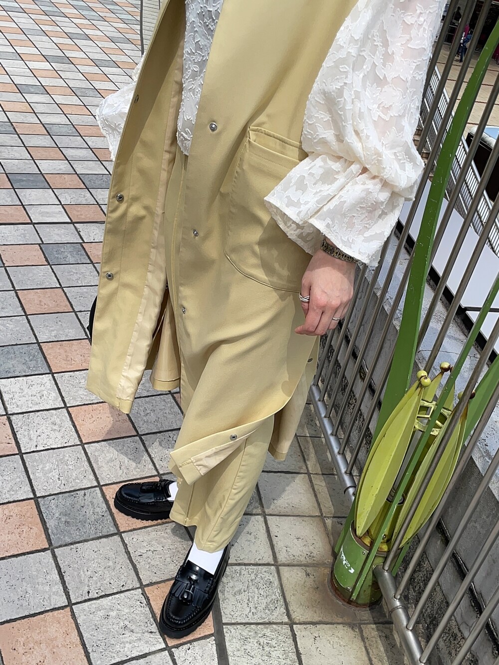 イエロー系のベスト、ホワイト系のシャツ/ブラウス、イエロー系のスラックスを着用したレディースの春コーディネートの3枚目の写真