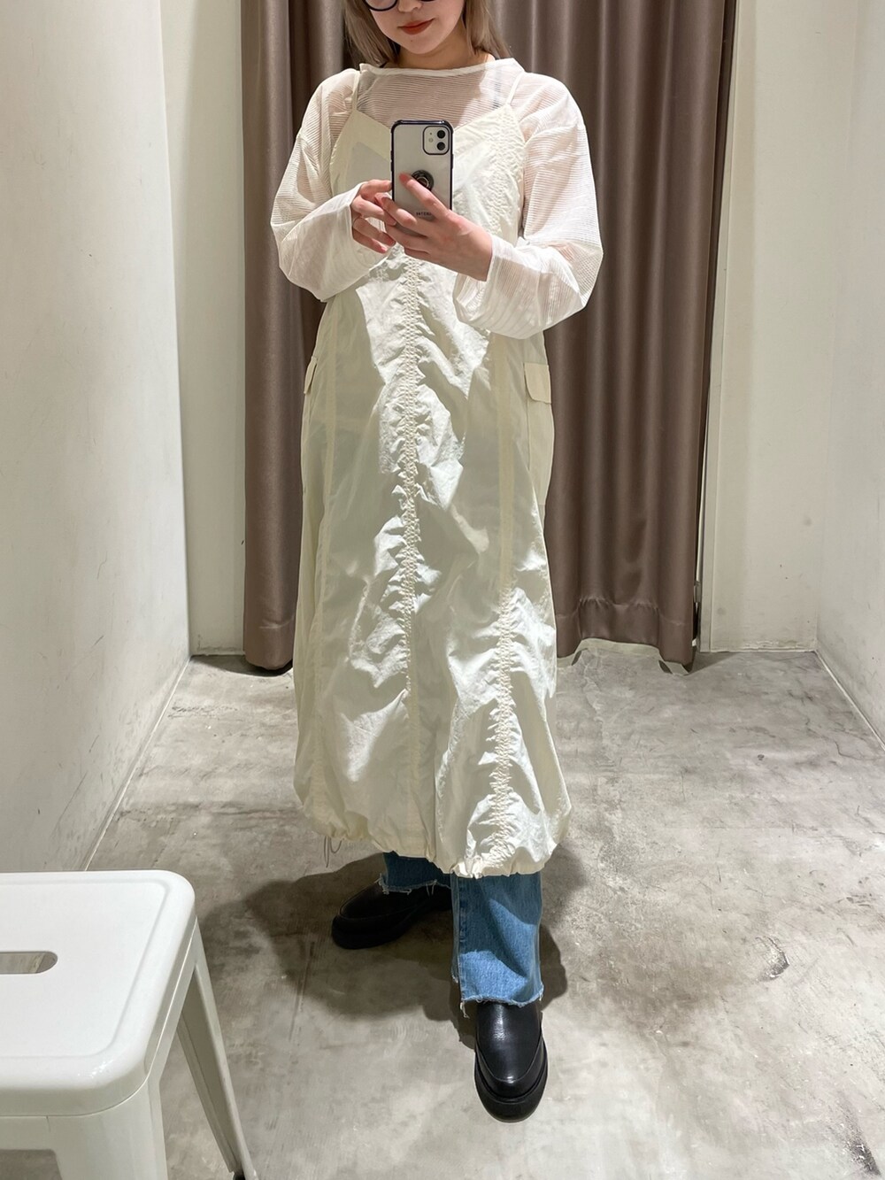 ホワイト系のTシャツ/カットソー、ブラック系のワンピース/ドレス、ブルー系のデニムパンツを着用したレディースの春コーディネートの2枚目の写真