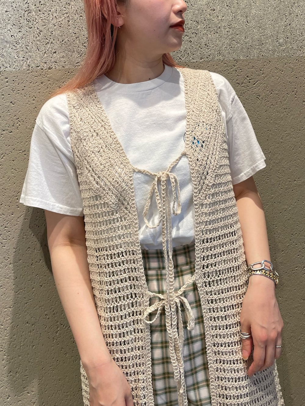 ホワイト系のニット/セーター、ホワイト系のTシャツ/カットソー、ベージュ系のスラックスを着用したレディースの夏コーディネートの3枚目の写真