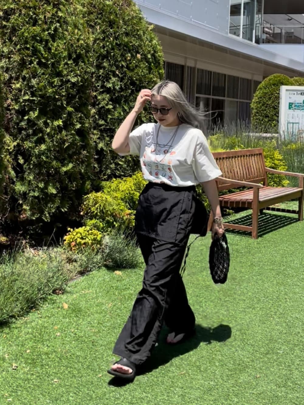 ホワイト系のTシャツ/カットソー、ブラック系のサロペット/オーバーオール、ブラック系のバッグを着用したレディースの夏コーディネートの6枚目の写真