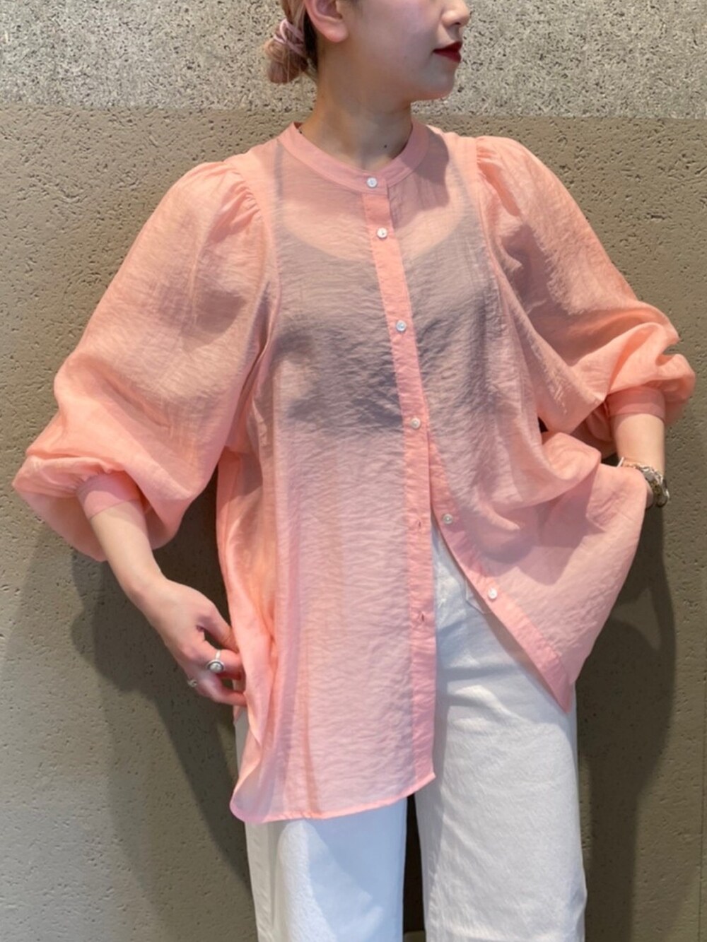 ピンク系のシャツ/ブラウス、ブラック系のサンダル、ホワイト系のデニムパンツを着用したレディースの春コーディネートの2枚目の写真