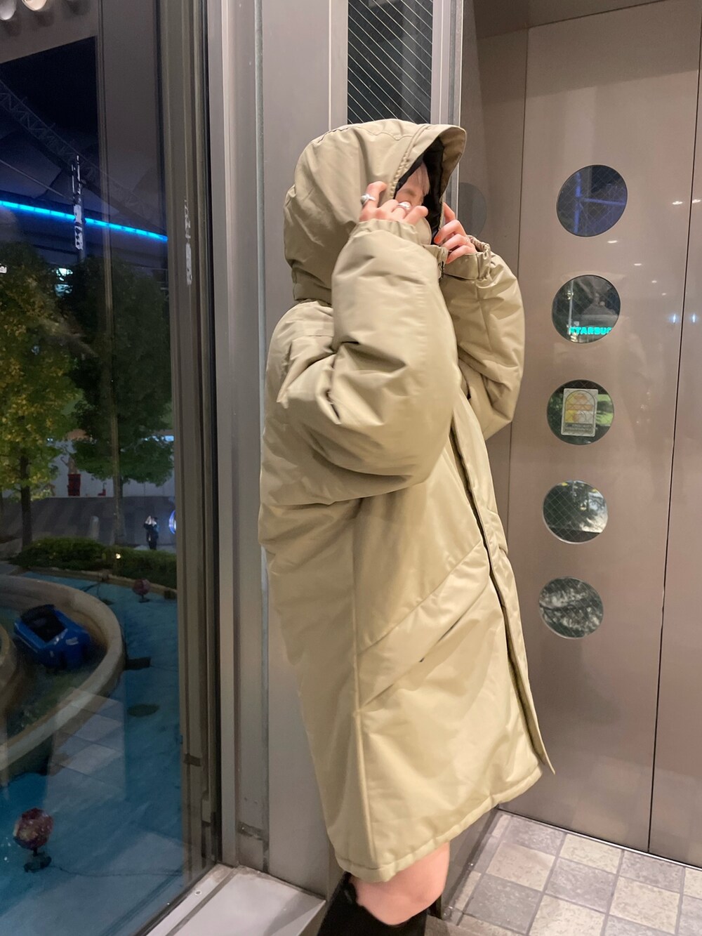 ベージュ系のダウンジャケット/コート、ブラック系のその他パンツ、ブラック系のブーツを着用したレディースの冬コーディネートの4枚目の写真