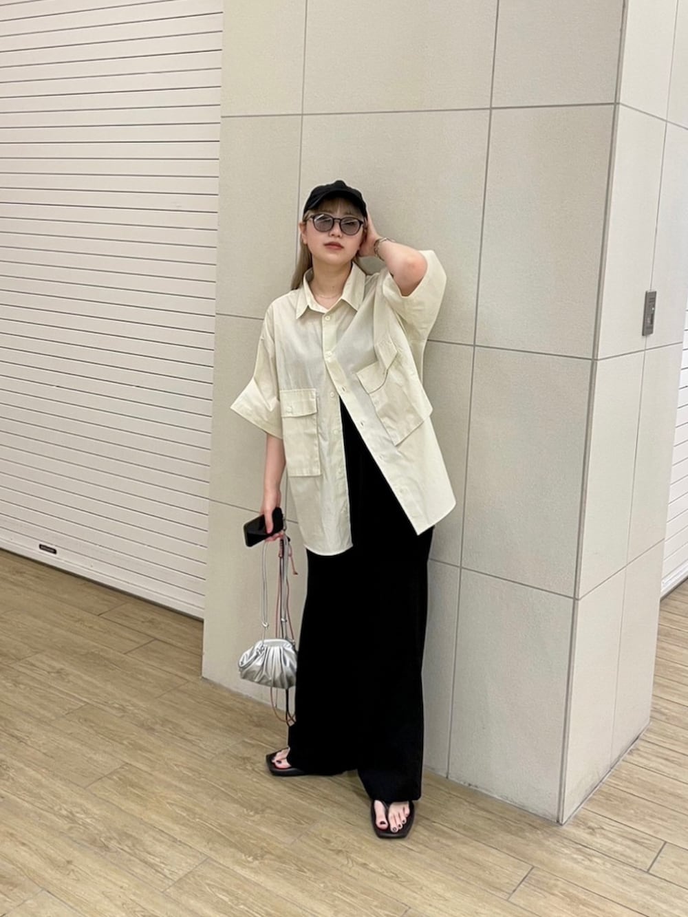 ベージュ系のシャツ/ブラウス、シルバー系のショルダーバッグ、ブラック系のサンダルを着用したレディースの夏コーディネートの2枚目の写真