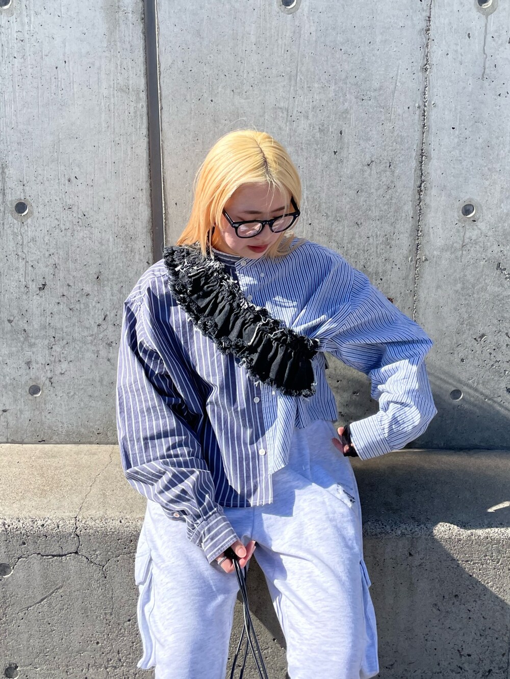 ブルー系のシャツ/ブラウス、ブラック系のデニムスカート、グレー系のパンツを着用したレディースの春コーディネートの8枚目の写真