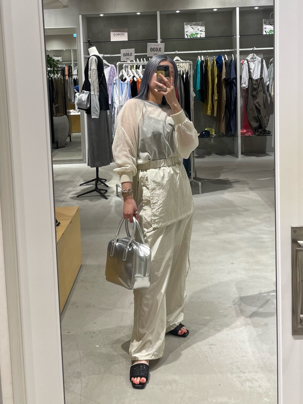 ホワイト系のニット/セーター、ホワイト系のサロペット/オーバーオール、シルバー系のバッグを着用したレディースの春コーディネートの9枚目の写真