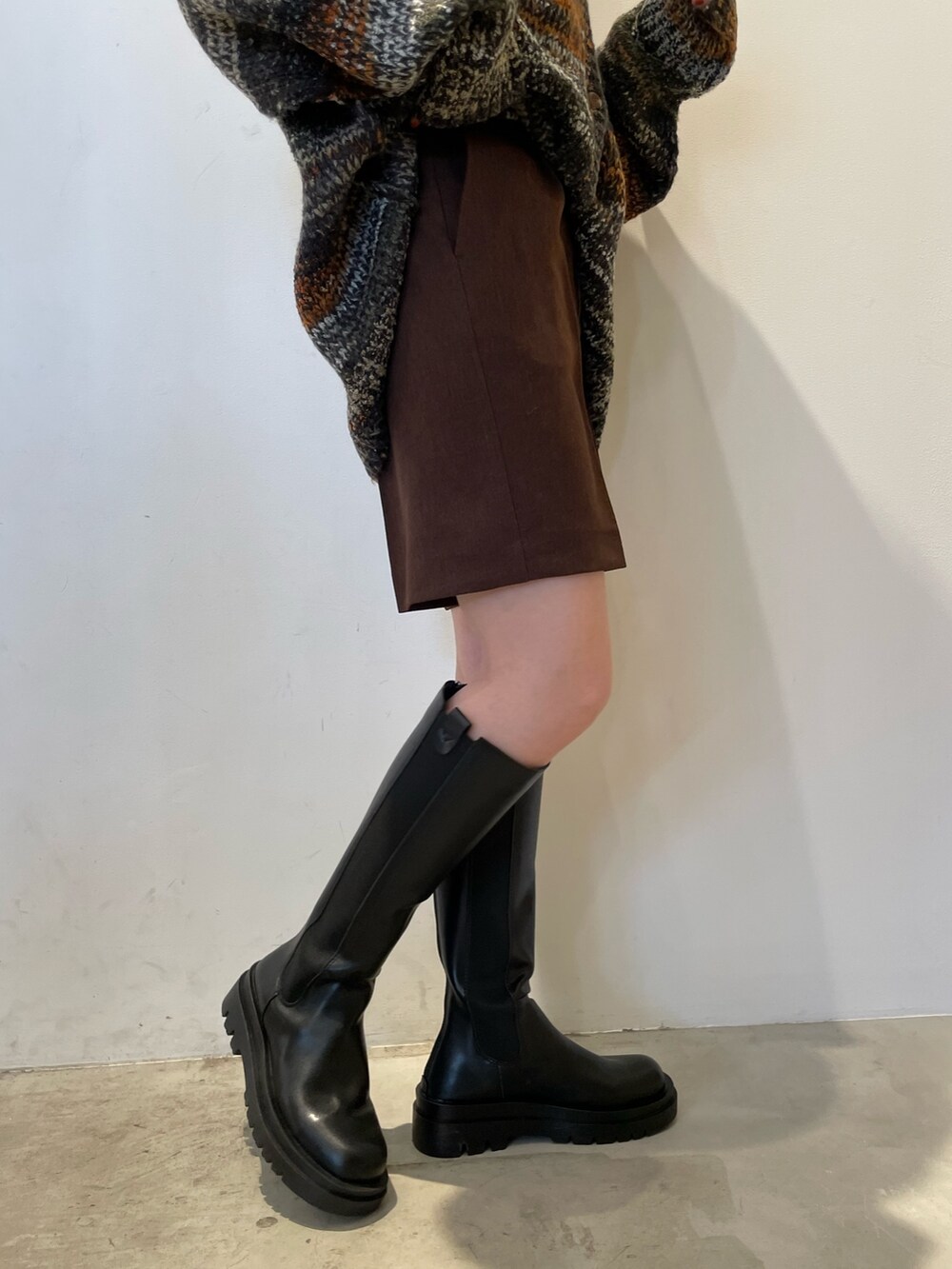 グリーン系のカーディガン/ボレロ、ブラウン系のその他パンツ、ブラック系のブーツを着用したレディースの秋コーディネートの9枚目の写真