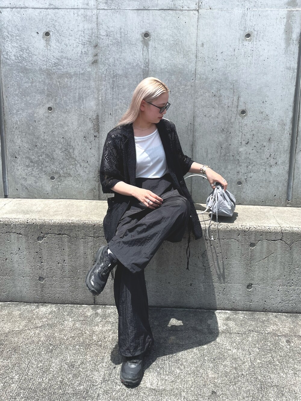 ブラック系のテーラードジャケット、グレー系のバッグ、ブラック系のサロペット/オーバーオールを着用したレディースの夏コーディネートの7枚目の写真