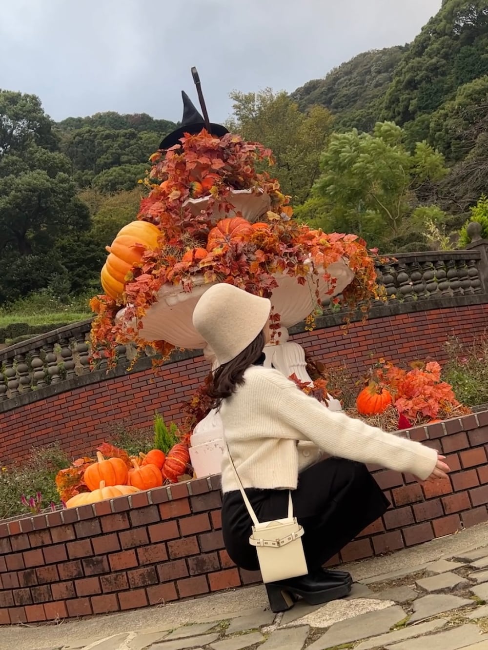 ブラック系のブーツ、ホワイト系のショルダーバッグ、ホワイト系のカーディガン/ボレロを着用したレディースの秋コーディネートの2枚目の写真