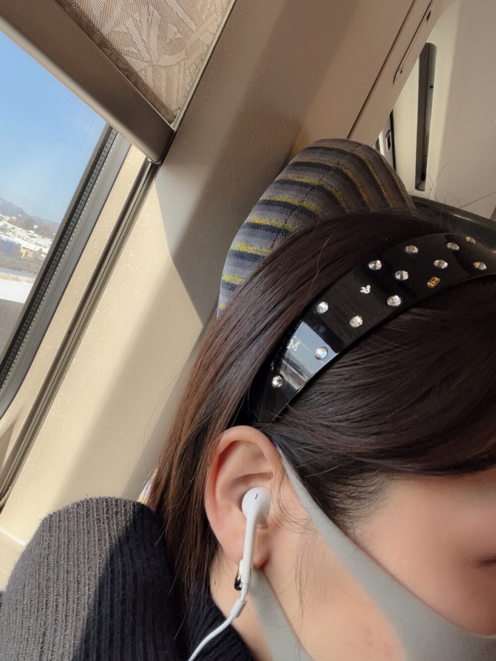 ブラック系のチェスターコート、ブラック系のブーツ、ブラック系のヘアバンドを着用したレディースの冬コーディネートの3枚目の写真