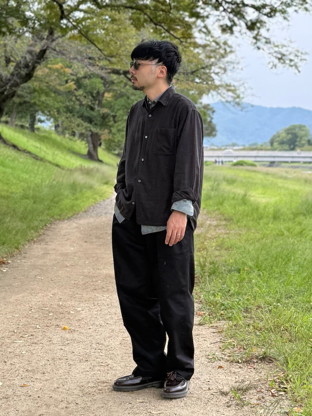 ブラック系のチノパンツ、ブラック系のシャツ/ブラウス、レッド系のローファーを着用したメンズの秋コーディネートの4枚目の写真
