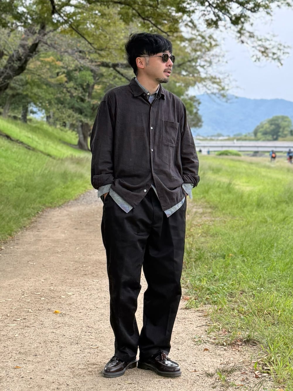 ブラック系のチノパンツ、ブラック系のシャツ/ブラウス、レッド系のローファーを着用したメンズの秋コーディネートの3枚目の写真