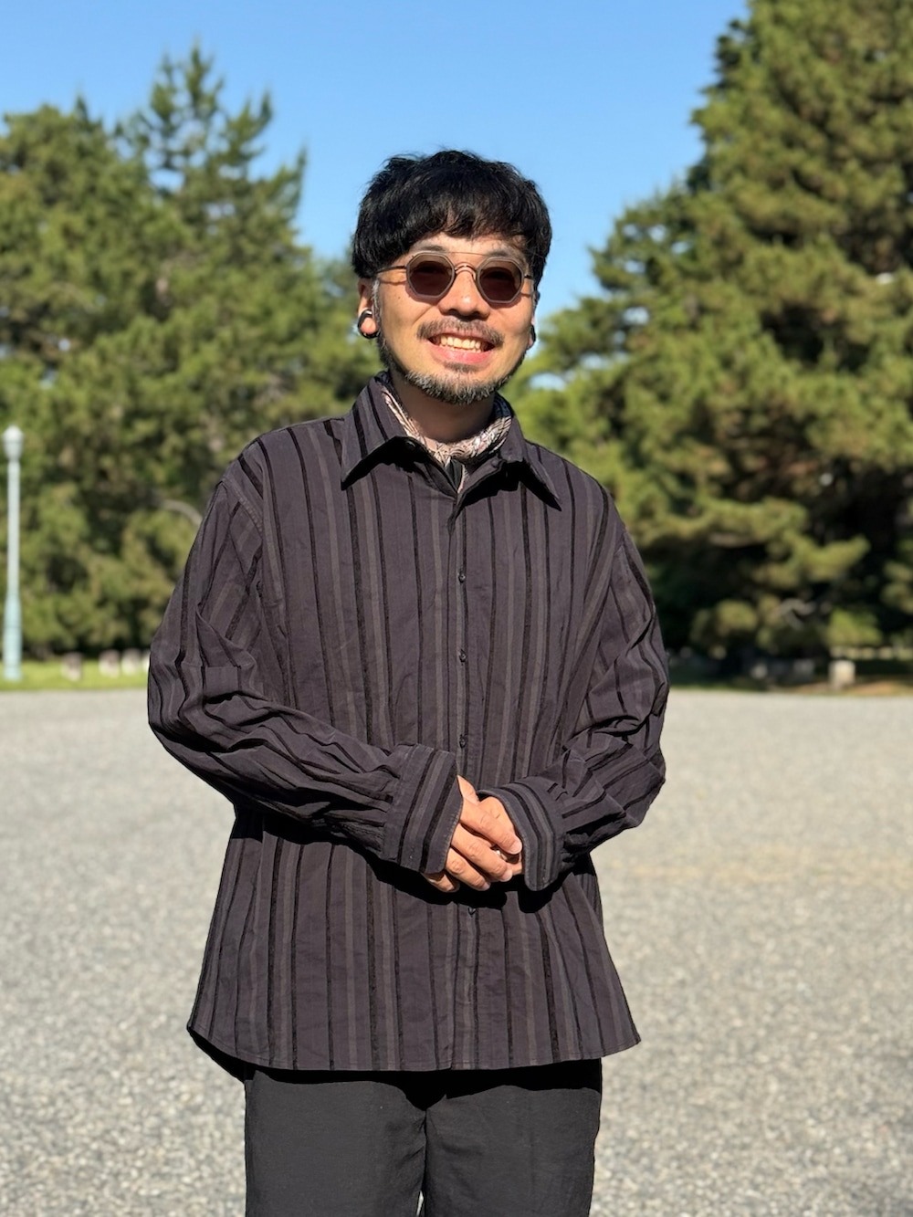ブラック系のスニーカー、ブラック系のパンツを着用したメンズの夏コーディネートの5枚目の写真