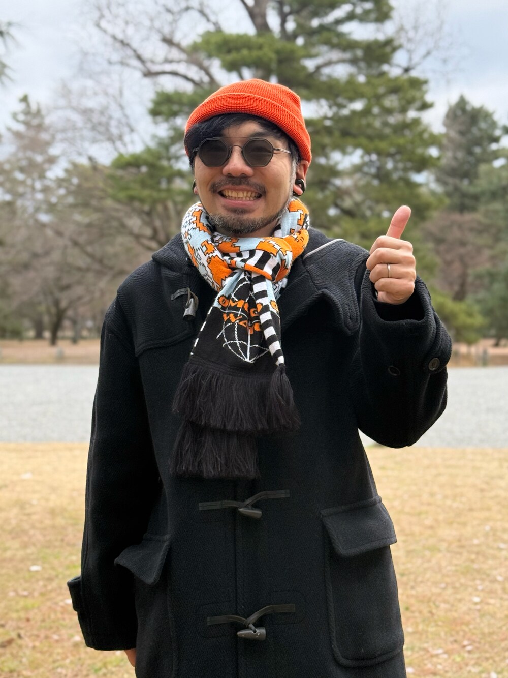 ブラック系のパンツ、ブラック系のスニーカー、オレンジ系のニットキャップ/ビーニーを着用したメンズの冬コーディネートの5枚目の写真