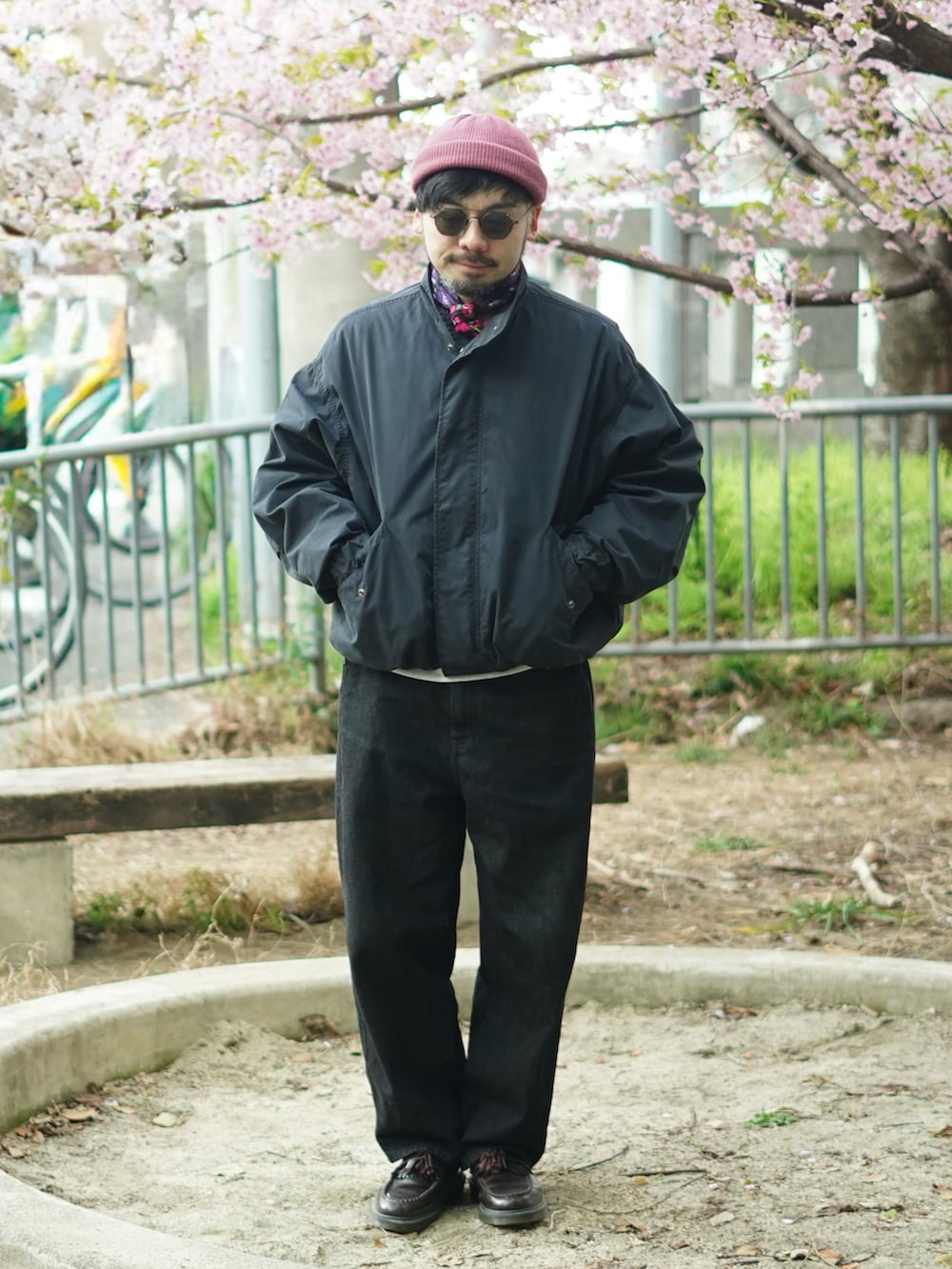 ブラック系のモッズコート、レッド系のローファー、ブラック系のデニムパンツを着用したメンズの春コーディネートの3枚目の写真