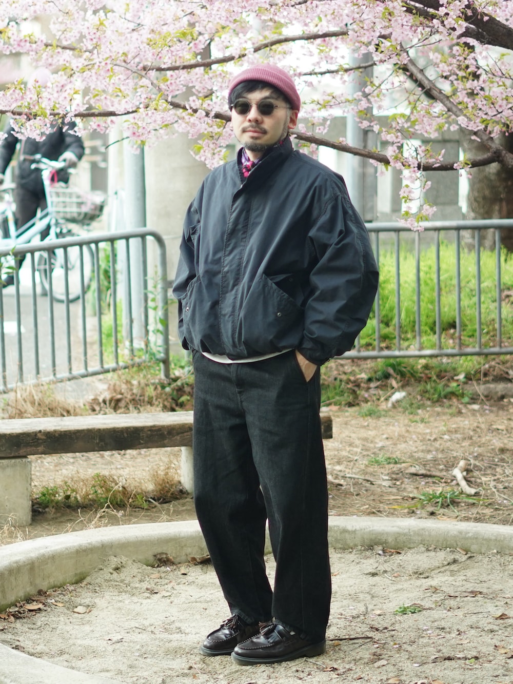 ブラック系のモッズコート、レッド系のローファー、ブラック系のデニムパンツを着用したメンズの春コーディネートの4枚目の写真