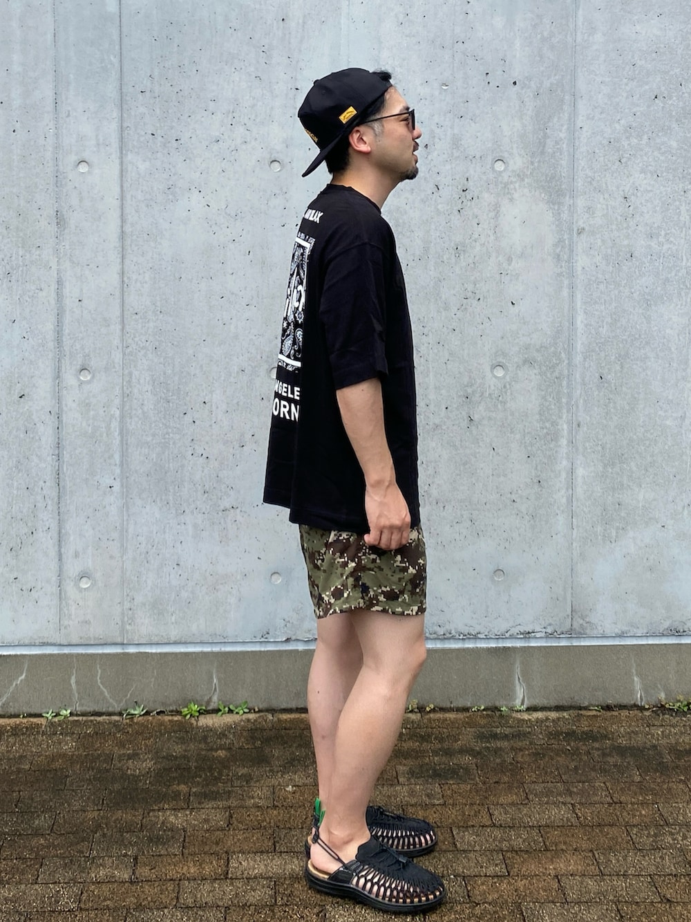その他のその他パンツ、ブラック系のサンダル、ブラック系のキャップを着用したメンズの夏コーディネートの2枚目の写真