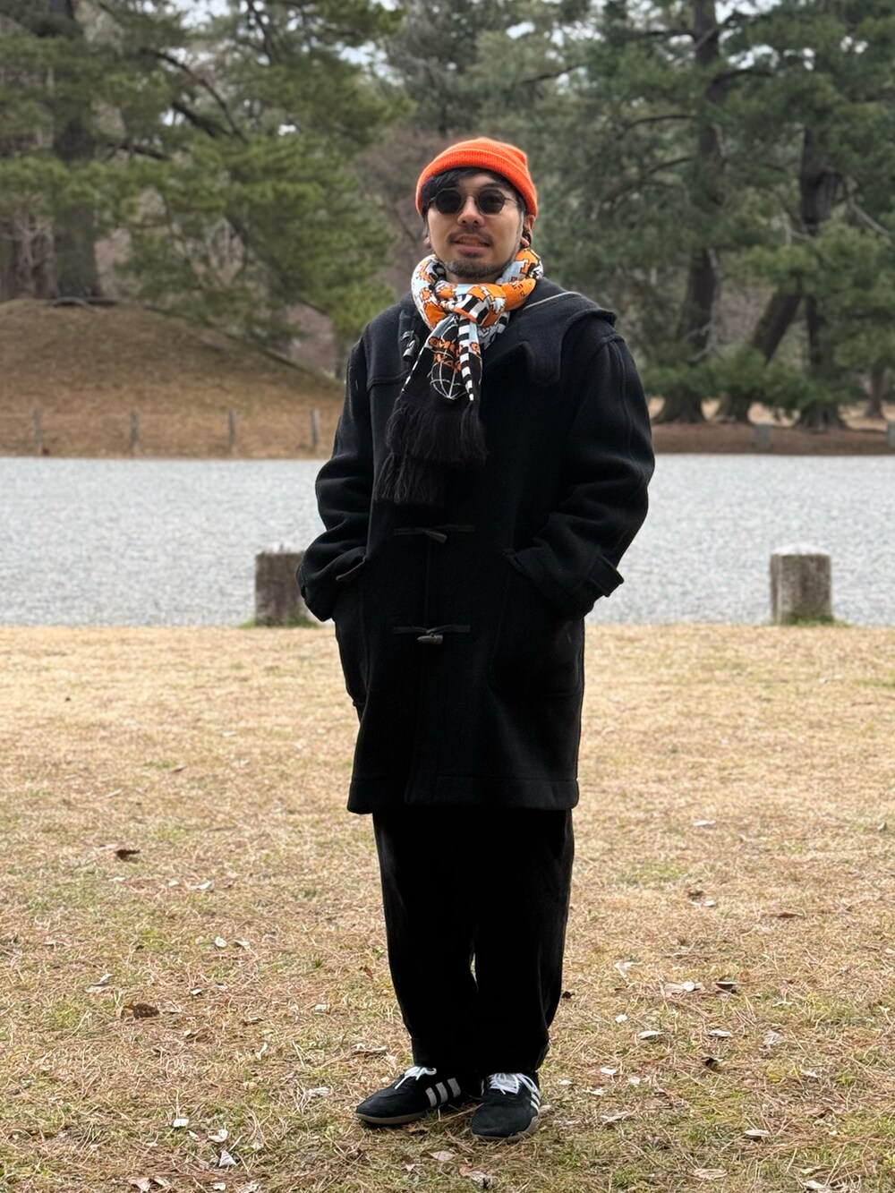 ブラック系のパンツ、ブラック系のスニーカー、オレンジ系のニットキャップ/ビーニーを着用したメンズの冬コーディネートの3枚目の写真