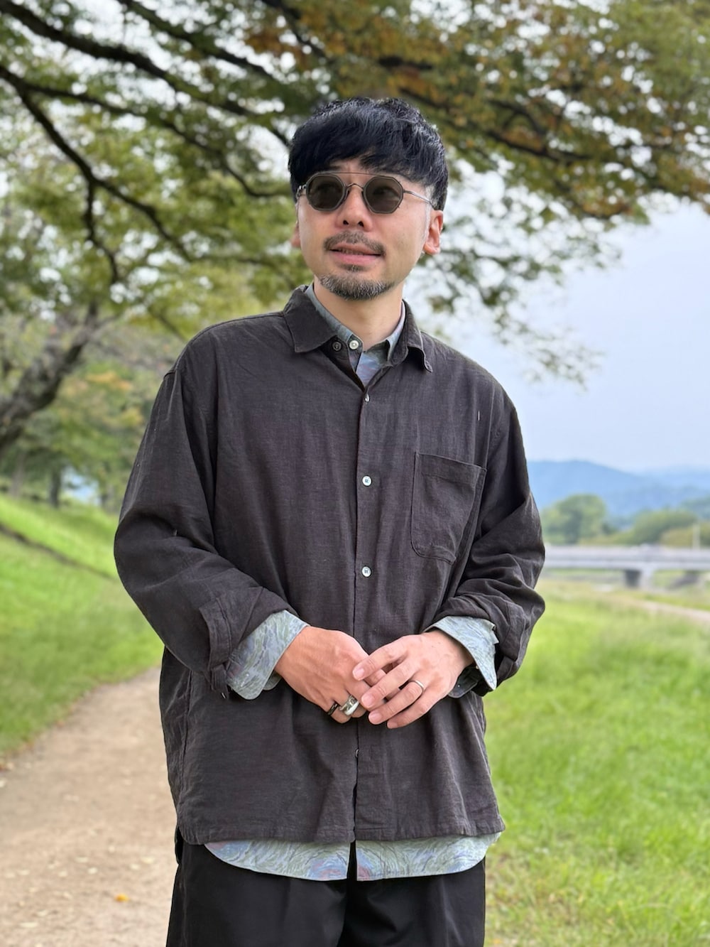 ブラック系のチノパンツ、ブラック系のシャツ/ブラウス、レッド系のローファーを着用したメンズの秋コーディネートの5枚目の写真