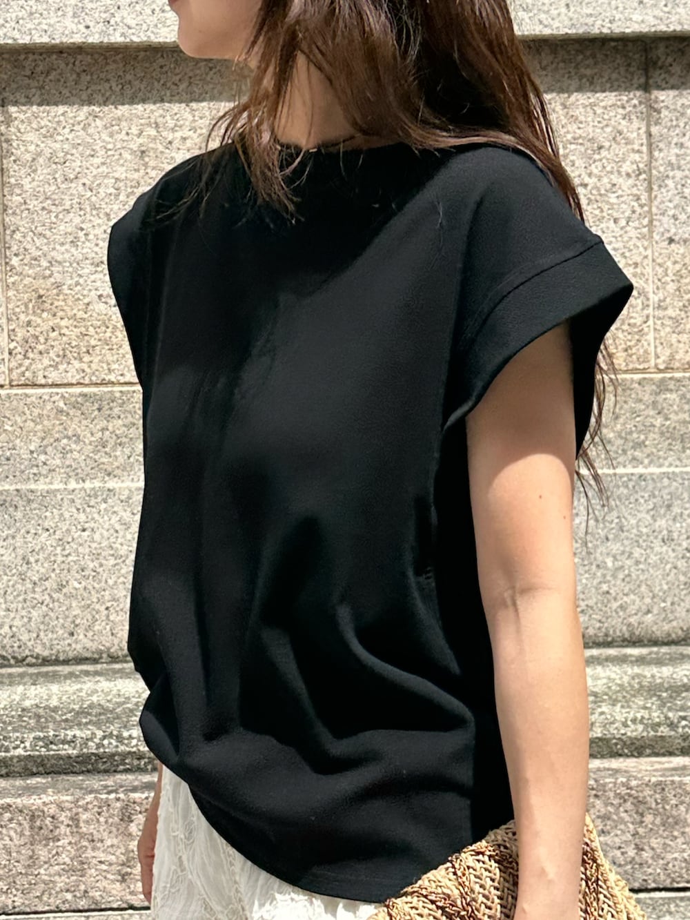 ブラック系のTシャツ/カットソー、ベージュ系のパンツを着用したレディースの夏コーディネートの4枚目の写真