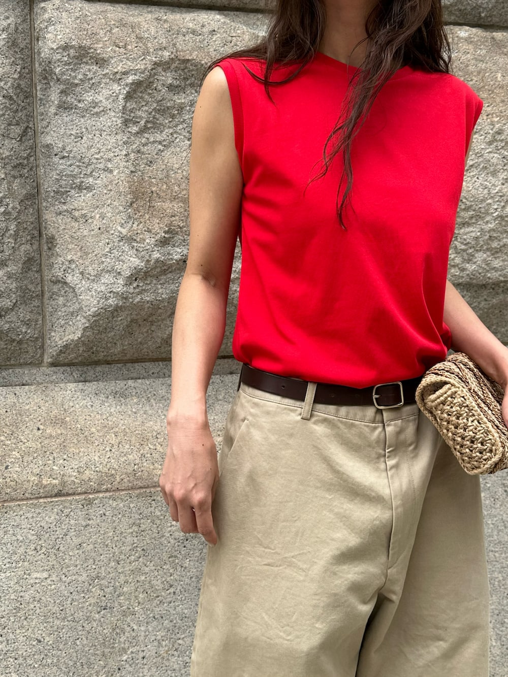 ベージュ系のチノパンツ、レッド系のタンクトップを着用したレディースの夏コーディネートの2枚目の写真