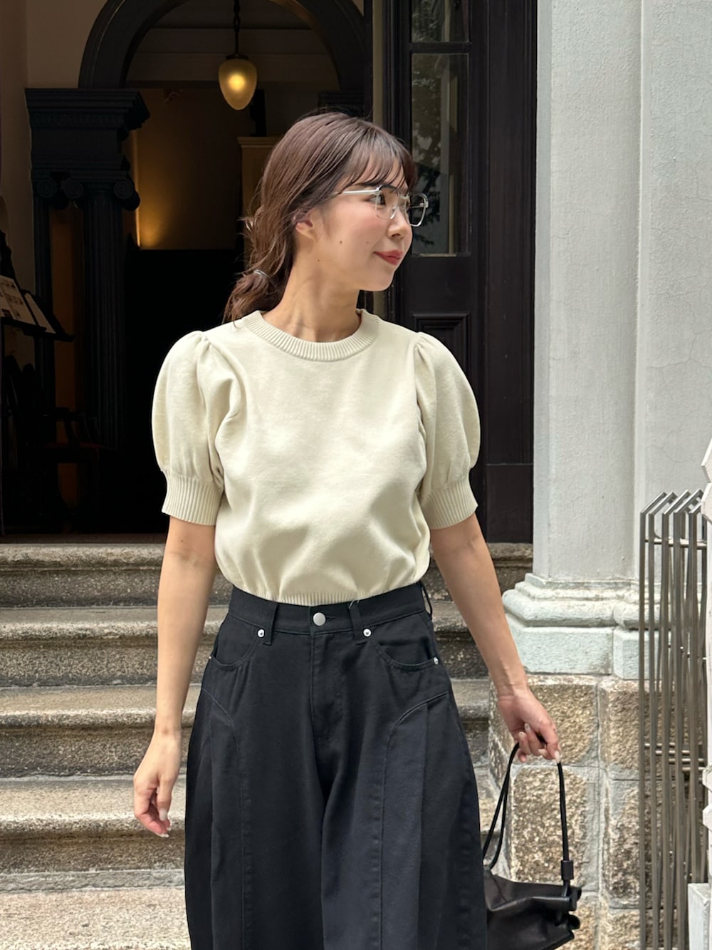 ベージュ系のTシャツ/カットソー、ブラック系のパンツを着用したレディースの夏コーディネートの3枚目の写真