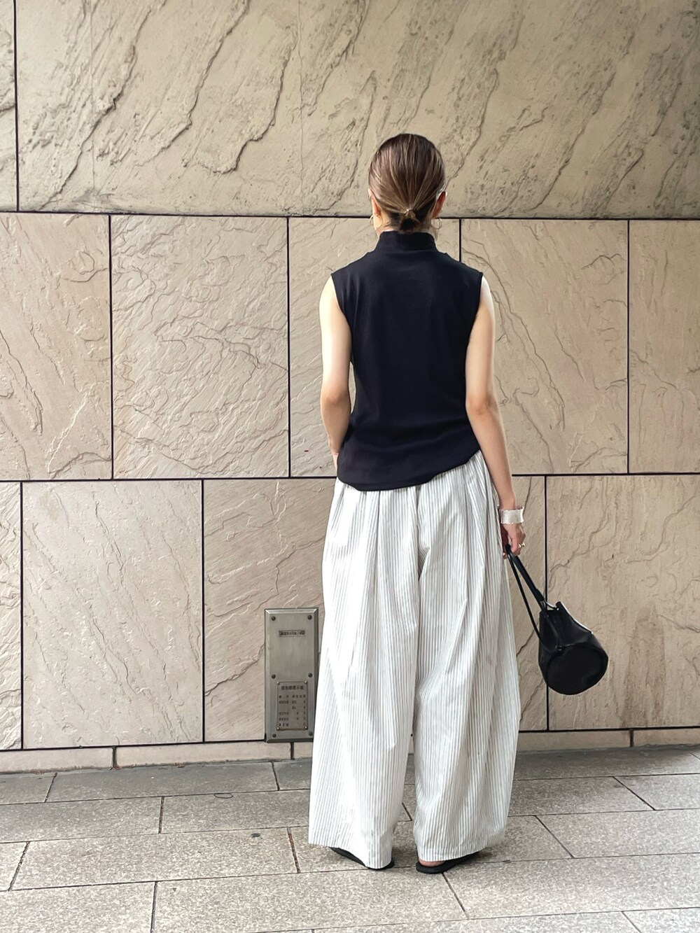 ブラック系のタンクトップ、ホワイト系のその他パンツを着用したレディースの春コーディネートの2枚目の写真
